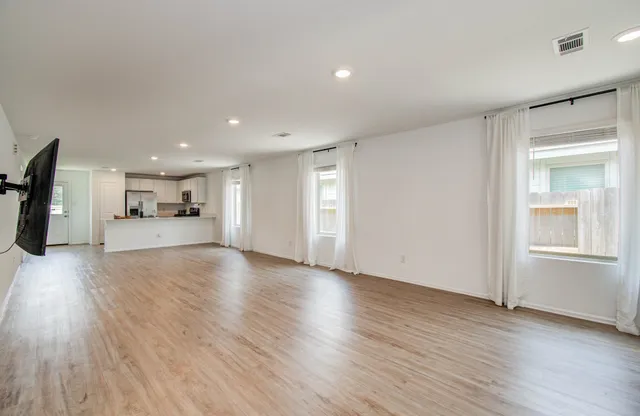 a view of empty room with wooden floor