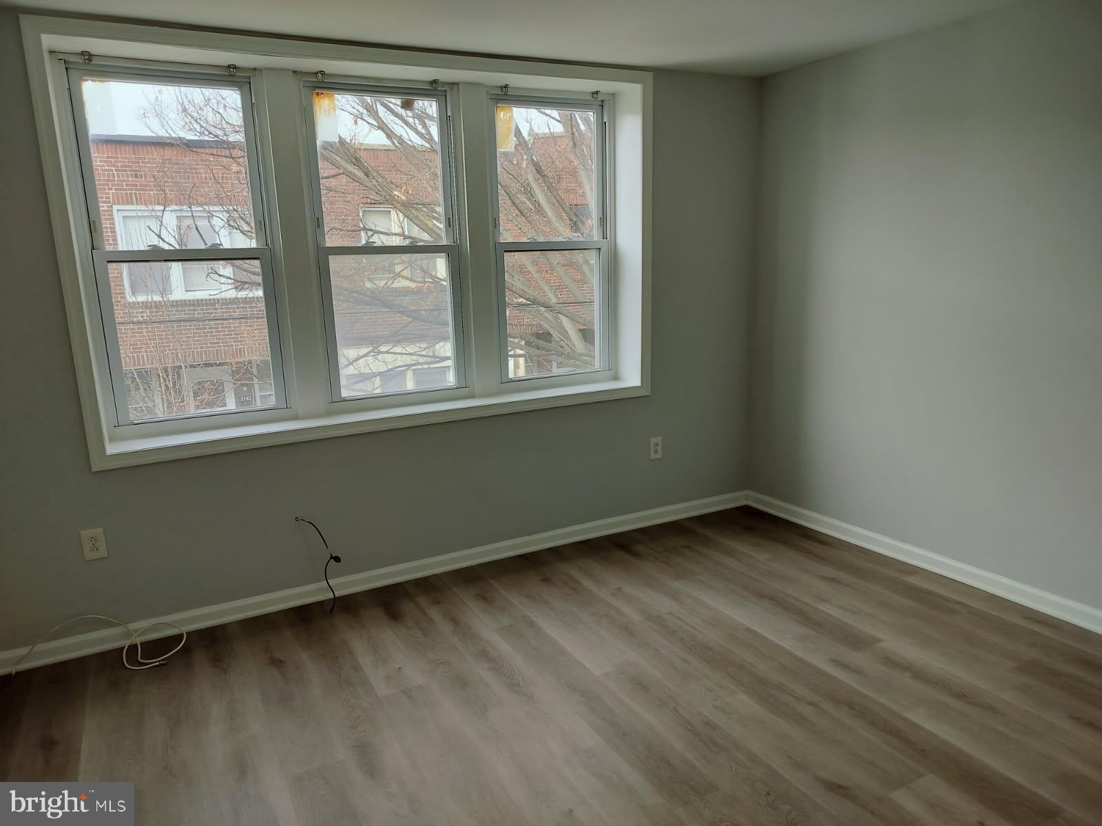 2143 South Beechwood Street Philadelphia, PA 19145 - Photo 6 of 14 an empty room with wooden floor and windows