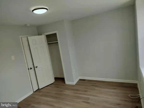 an empty room with wooden floor and white wall