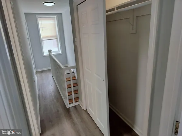 a view of a hallway with wooden floor and stairs