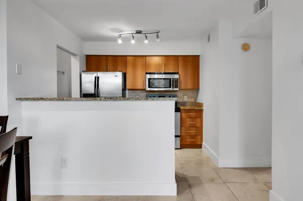a kitchen with granite countertop a refrigerator and a sink