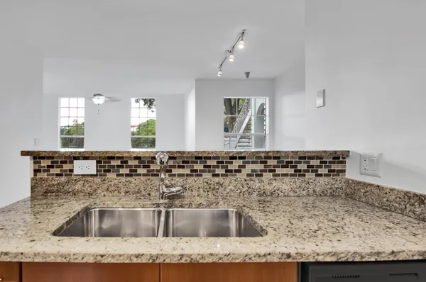 a kitchen with kitchen island granite countertop a sink and granite top