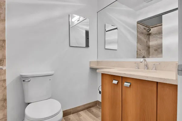 a bathroom with a toilet a sink a mirror and vanity
