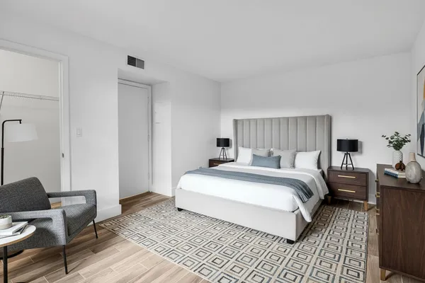 a bedroom with a bed and wooden floor