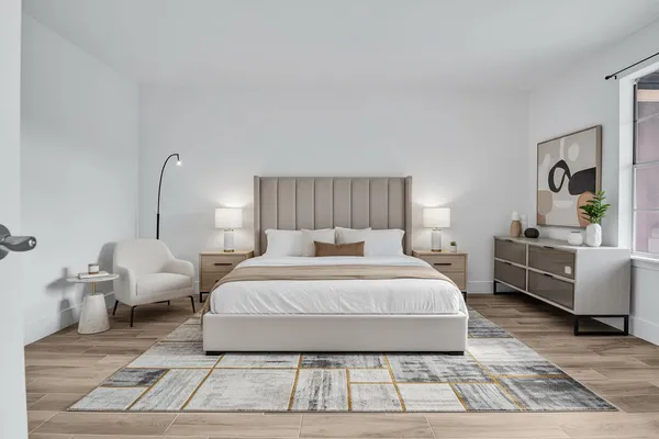 a spacious bedroom with a bed a couch and dresser