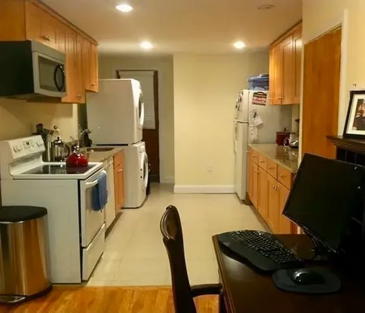 a kitchen with a refrigerator and a stove top oven