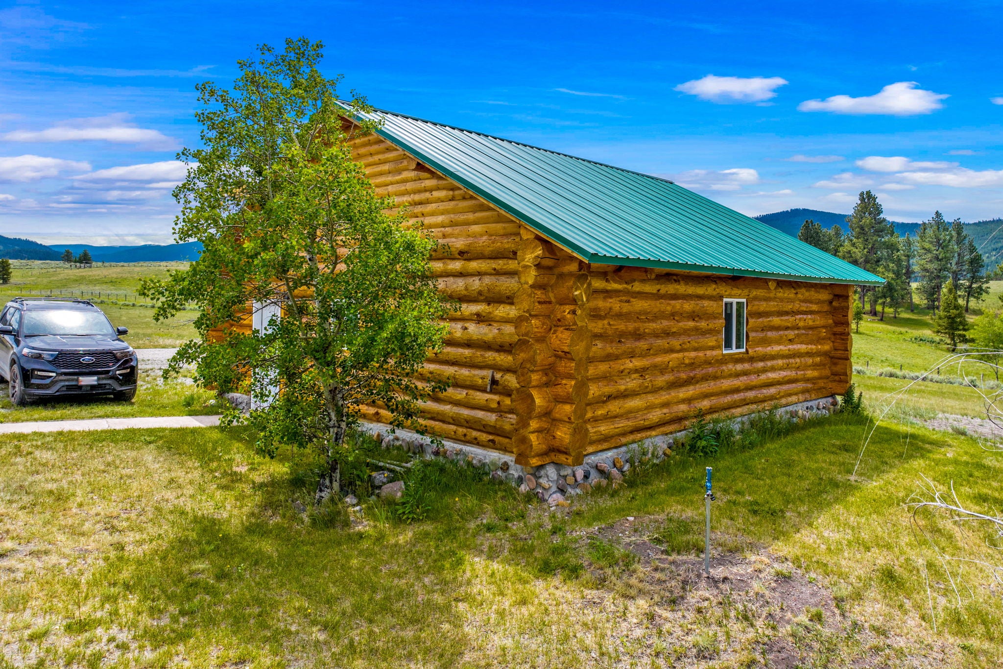 3358 Strandskov Road Lincoln, MT 59639 - Photo 64 of 80 View of side of home with log siding, a mountain view, and a metal roof