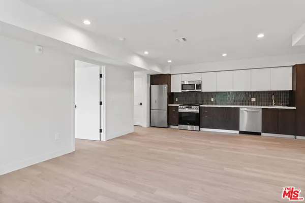 a view of kitchen with kitchen island and stainless steel appliances