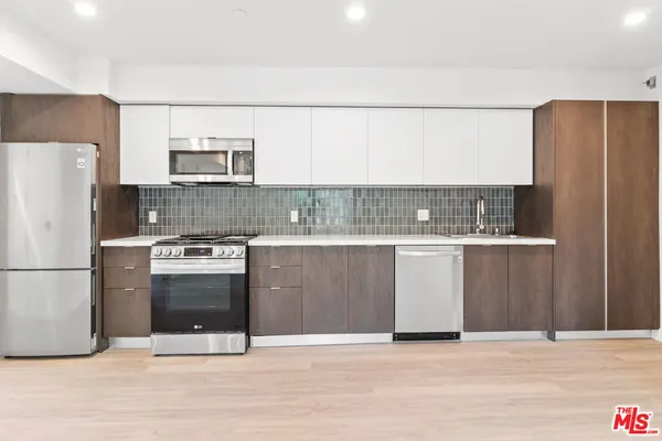 a kitchen with stainless steel appliances granite countertop a refrigerator and a stove
