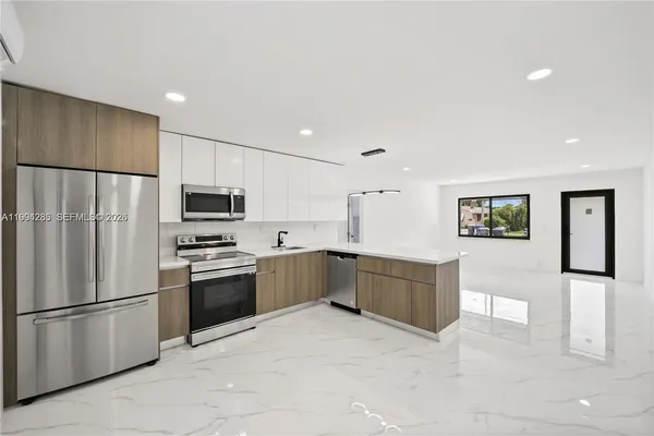 a large kitchen with a refrigerator and a stove top oven