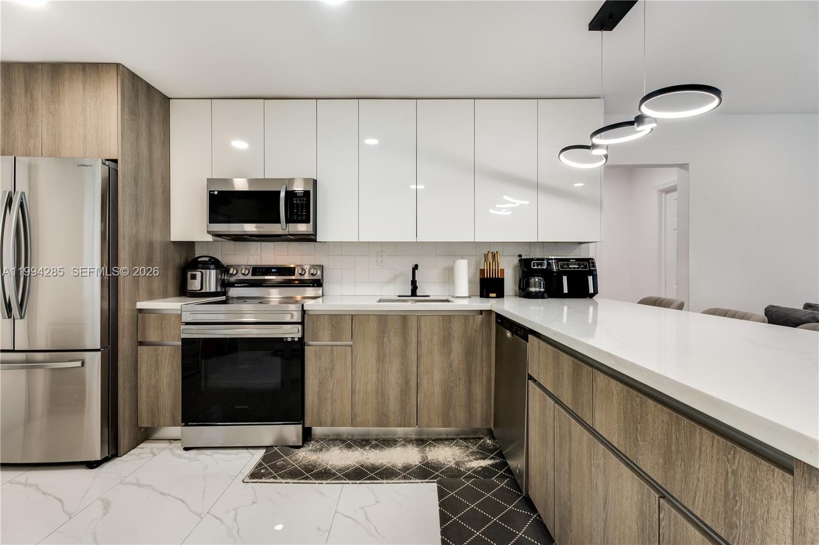 5635 Pierce Street Hollywood, FL 33021 - Photo 14 of 27 a kitchen with a sink stainless steel appliances and cabinets