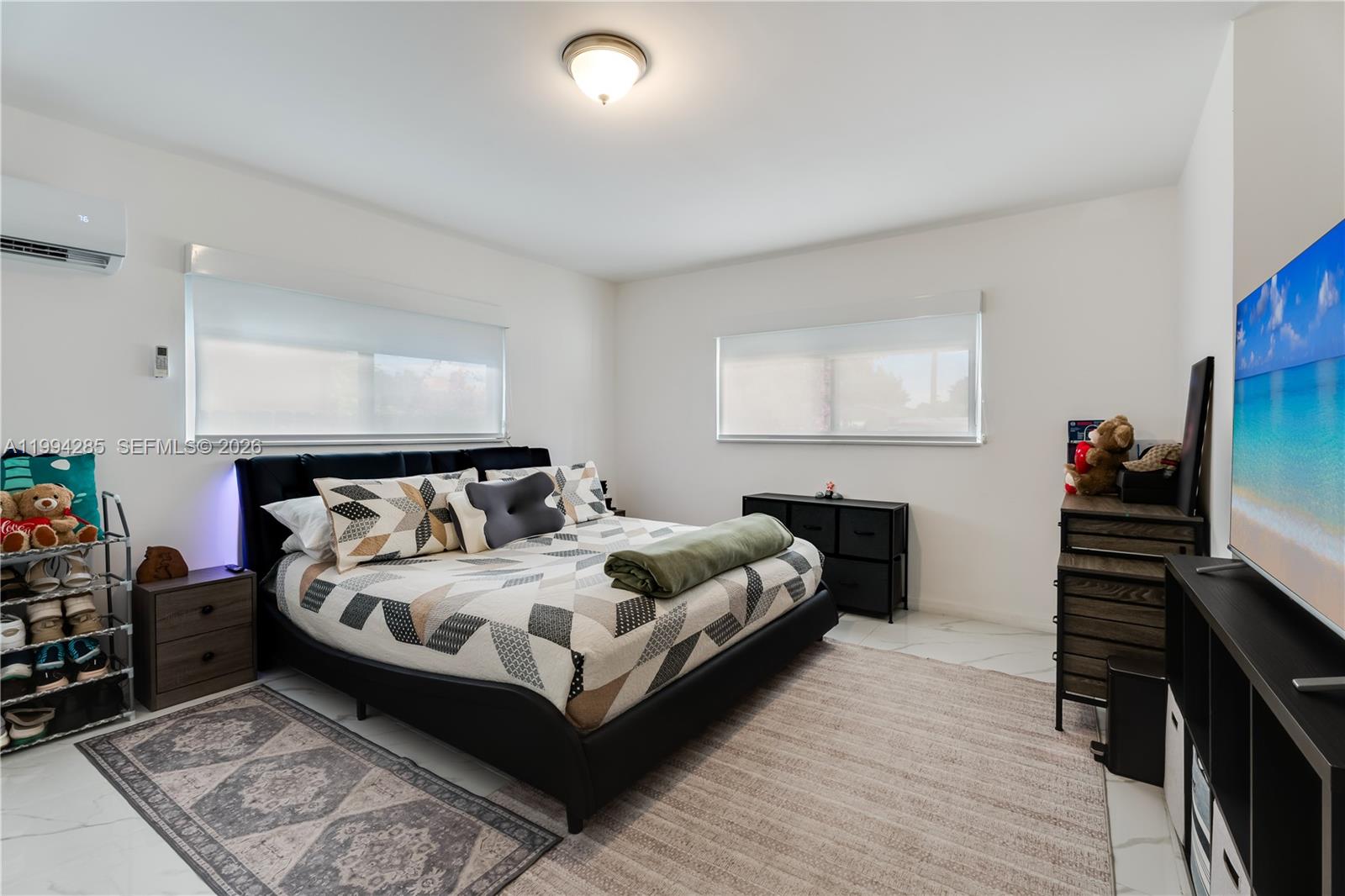 5635 Pierce Street Hollywood, FL 33021 - Photo 19 of 27 a bedroom with a bed and a flat tv screen on the dresser