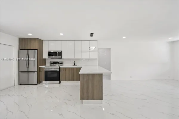 a kitchen with stainless steel appliances a refrigerator and a stove top oven