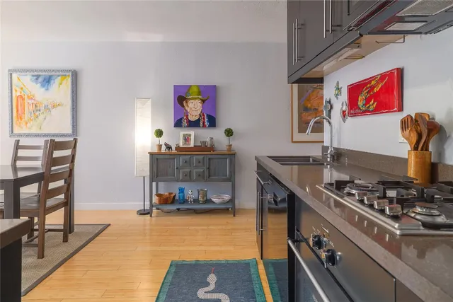 a open kitchen with stainless steel appliances granite countertop a stove a sink and a microwave