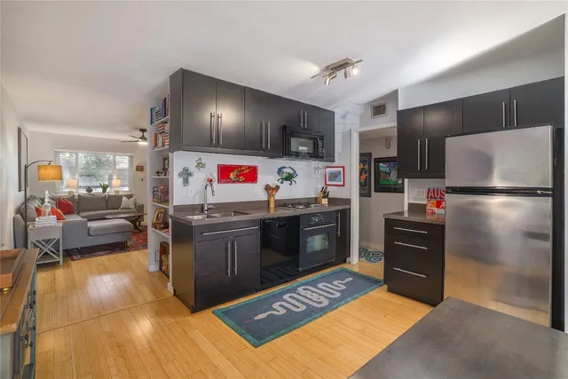 a kitchen with stainless steel appliances kitchen island granite countertop a refrigerator stove and sink