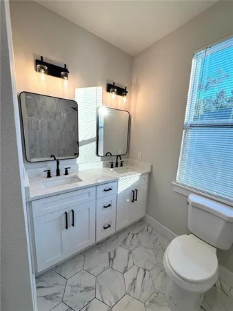 a bathroom with a toilet sink and mirror