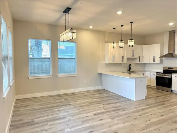 a large kitchen with stainless steel appliances kitchen island granite countertop a stove a sink a center island a stove and a window