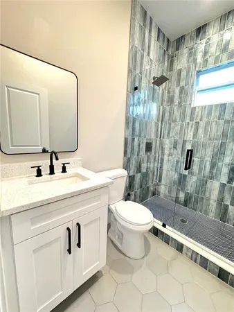 a bathroom with a double vanity sink toilet and shower