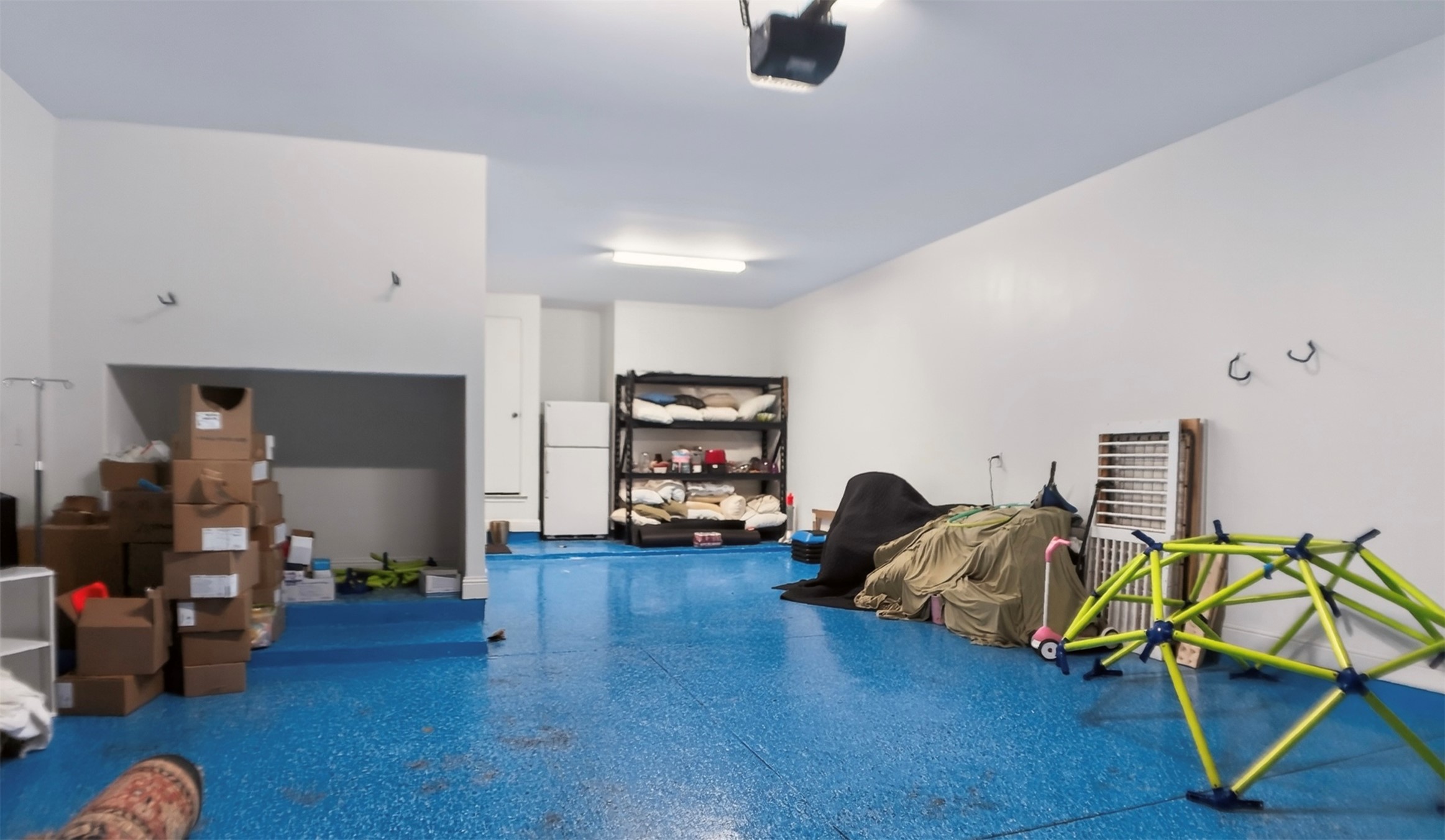 1505 Long Shadow Lane Georgetown, TX 78628 - Photo 18 of 28 Spacious garage with a blue speckled epoxy floor, white painted walls, and overhead lighting