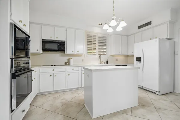 a kitchen with kitchen island granite countertop a sink a center island and cabinets