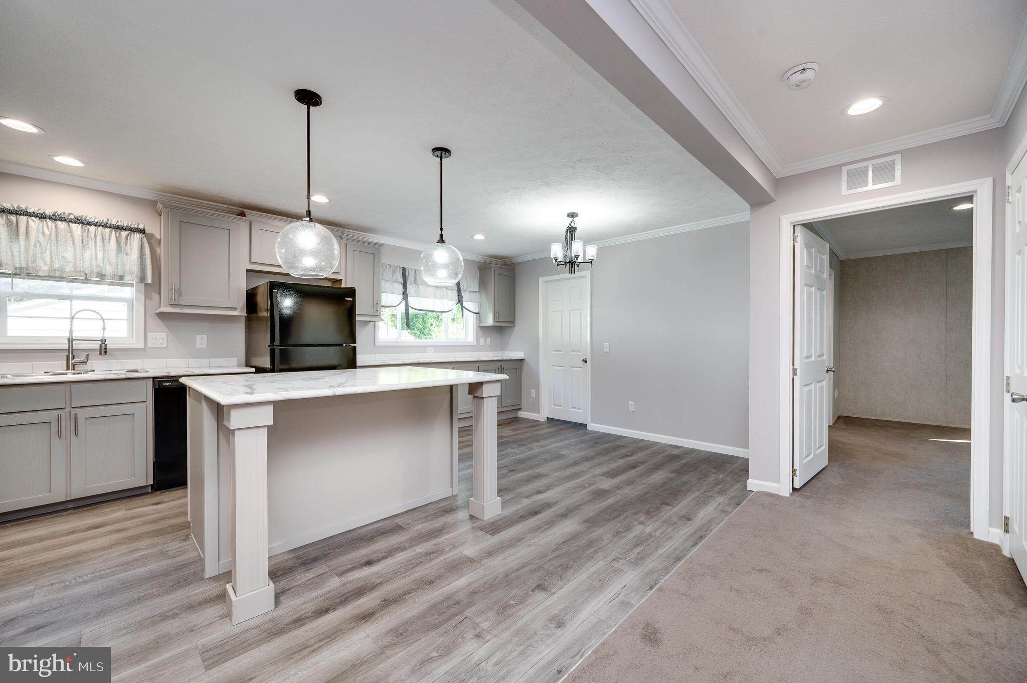 875 Mohrsville Road Shoemakersville, PA 19555 - Photo 34 of 34 a kitchen with stainless steel appliances kitchen island granite countertop a refrigerator a sink dishwasher a stove and white cabinets with wooden floor