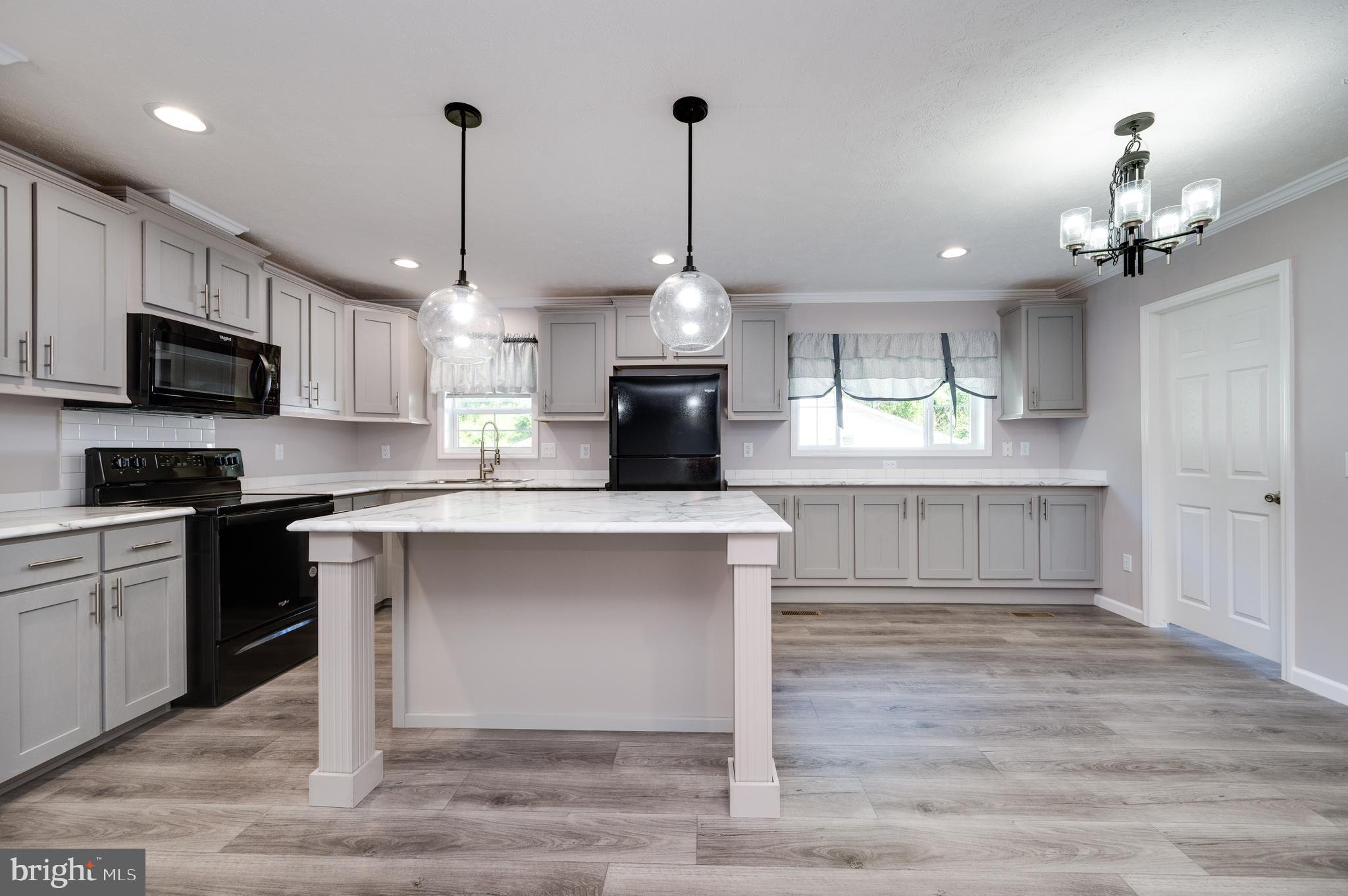 875 Mohrsville Road Shoemakersville, PA 19555 - Photo 15 of 34 a kitchen with kitchen island granite countertop a stove top oven a sink a counter space and cabinets