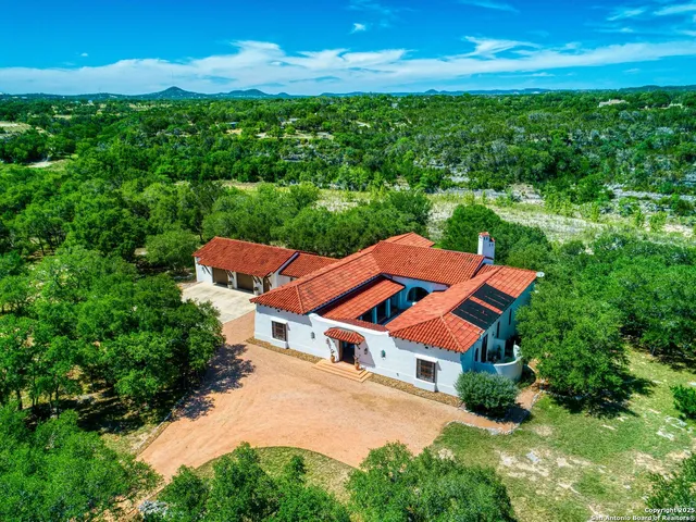 an aerial view of a house with swimming pool and garden