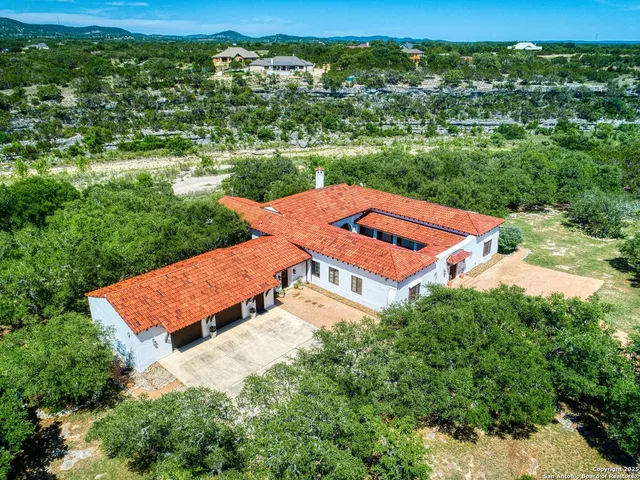 a view of a house with a yard and large trees