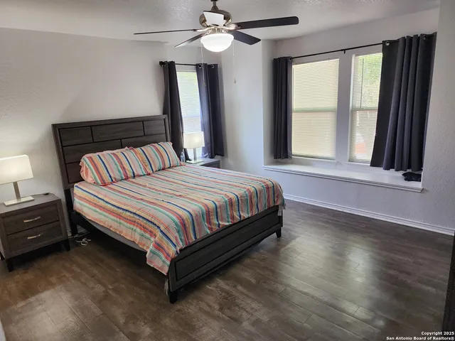 a bed sitting in a bedroom next to a window and a chandelier