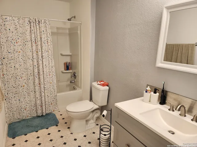 a bathroom with a sink a toilet a shower and a mirror