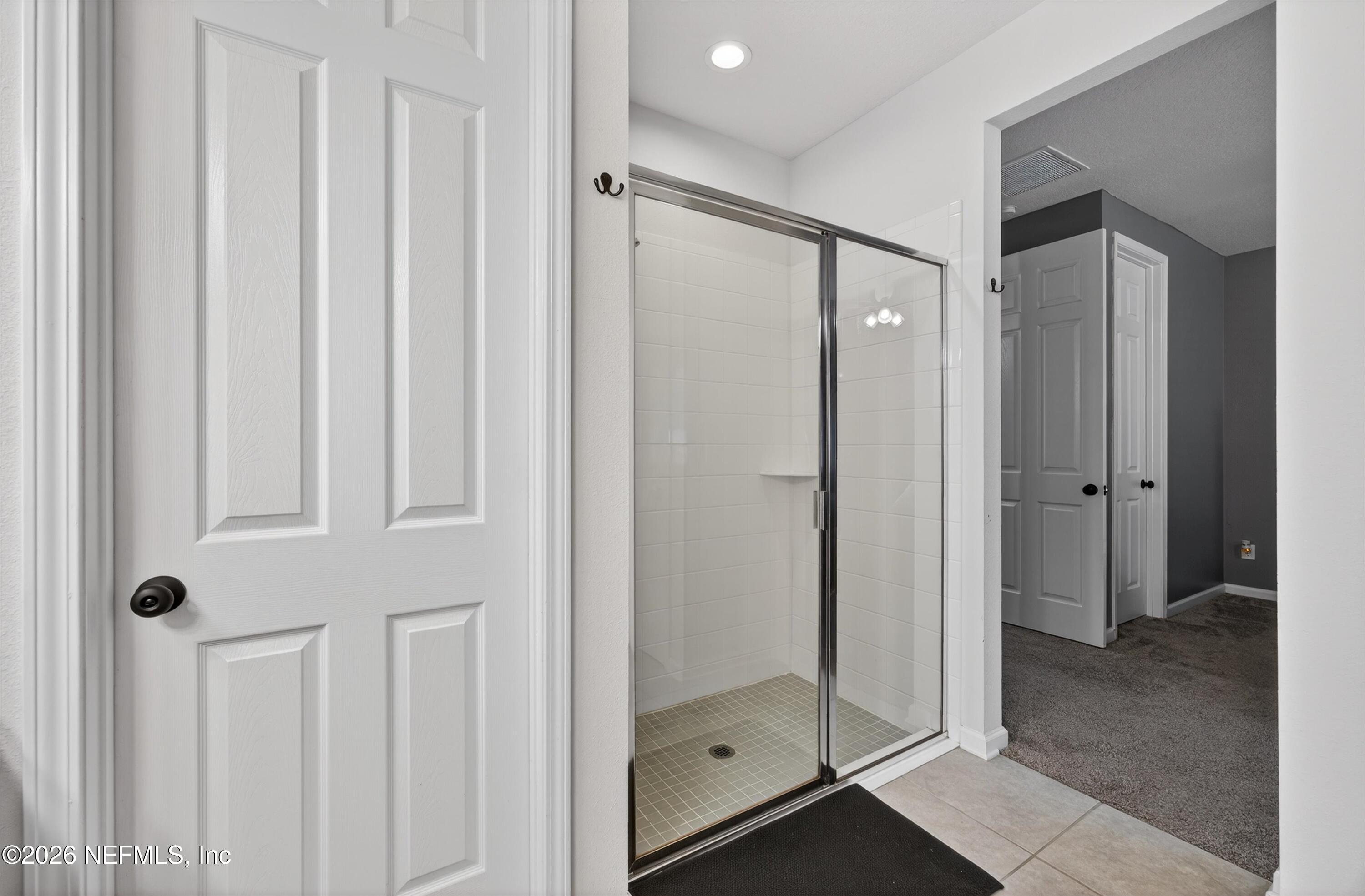 1062 Persimmon Drive Middleburg, FL 32068 - Photo 30 of 45 a bathroom with a glass shower door and a sink