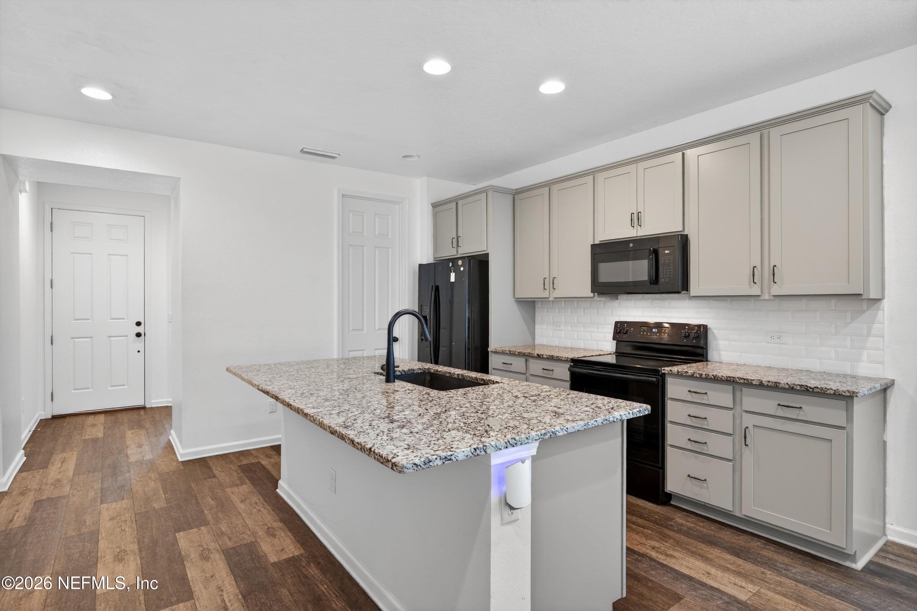 1062 Persimmon Drive Middleburg, FL 32068 - Photo 7 of 45 a kitchen with granite countertop a sink stove and refrigerator