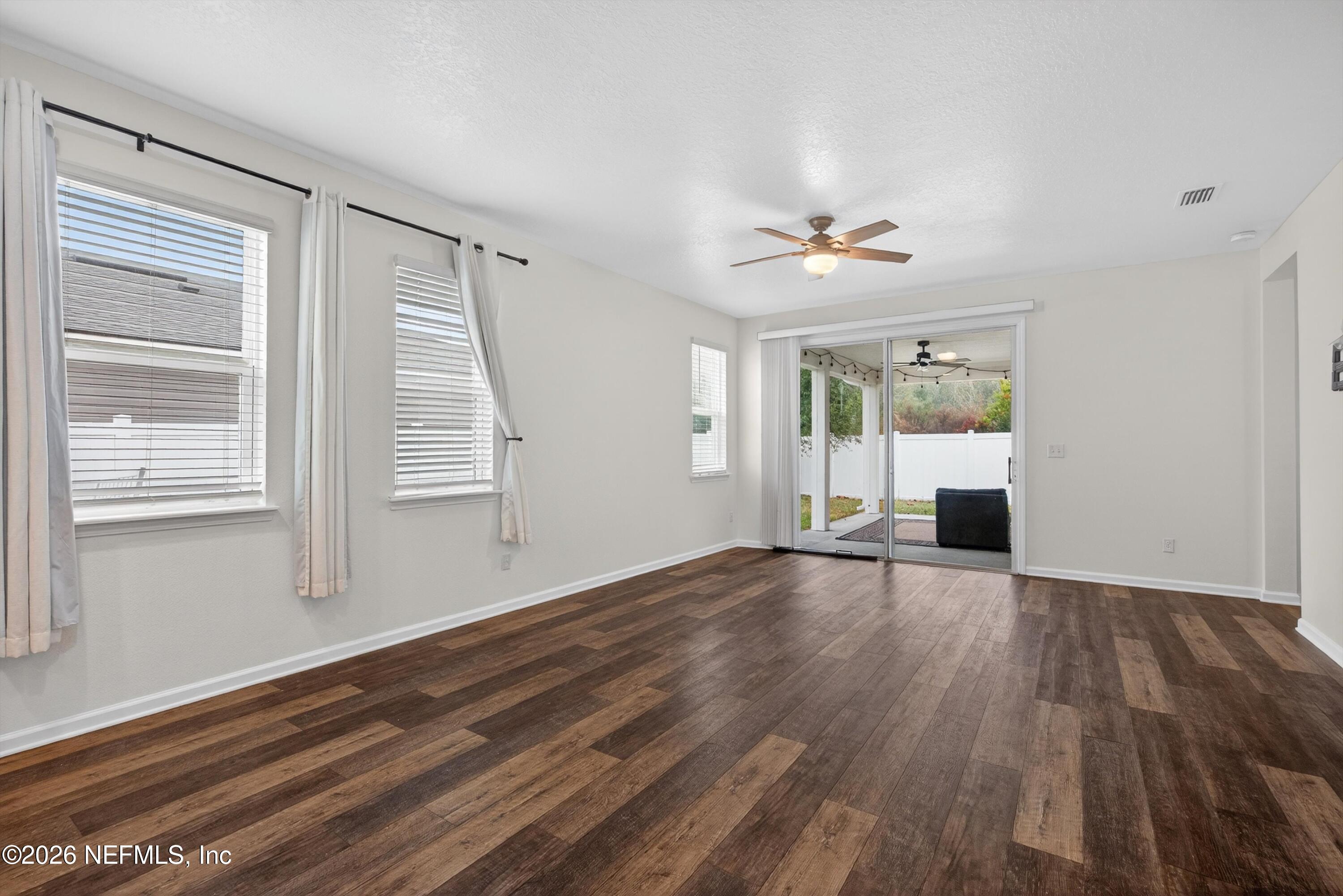 1062 Persimmon Drive Middleburg, FL 32068 - Photo 9 of 45 a view of an empty room with wooden floor and a window