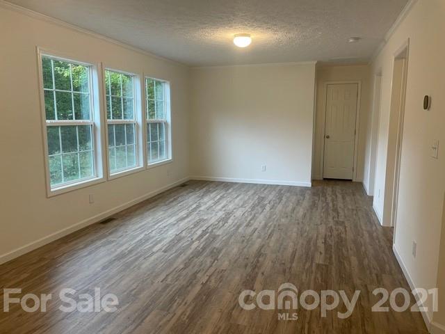 1471 Howard Gap Loop Road Flat Rock, NC 28731 - Photo 19 of 24 an empty room with wooden floor and windows