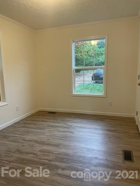 1471 Howard Gap Loop Road Flat Rock, NC 28731 - Photo 21 of 24 a view of an empty room with wooden floor and a window