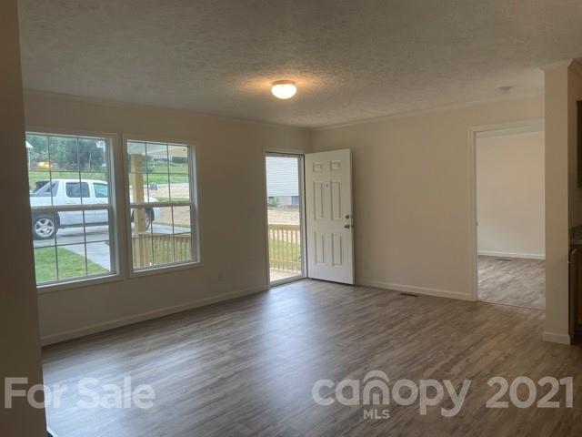 1471 Howard Gap Loop Road Flat Rock, NC 28731 - Photo 7 of 24 an empty room with wooden floor and windows