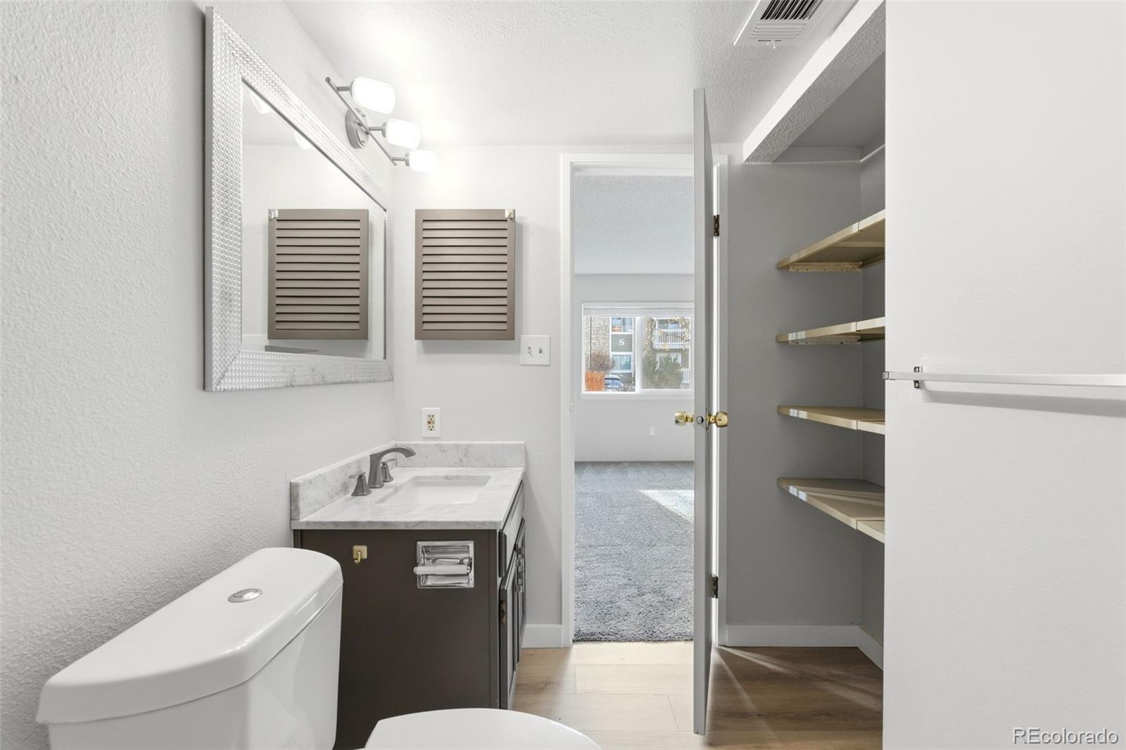 4400 South Quebec Street, Unit 108M Denver, CO 80237 - Photo 17 of 28 a bathroom with a toilet sink and a mirror