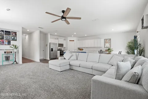a living room with furniture and kitchen view