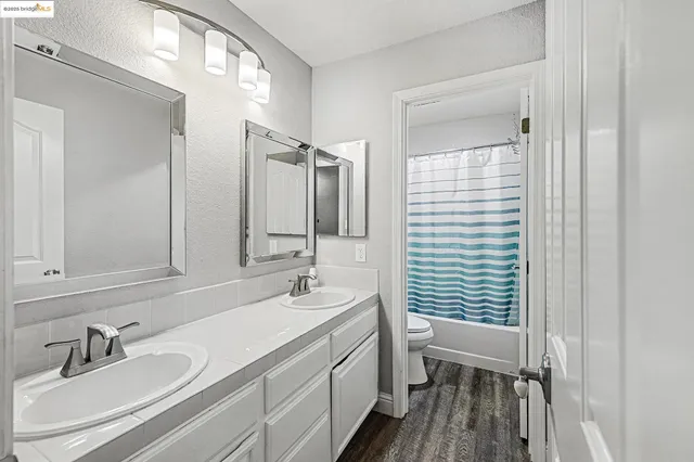 a bathroom with double vanity sink a mirror and a shower