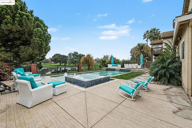 a view of a patio with couches and a table and chairs with wooden fence