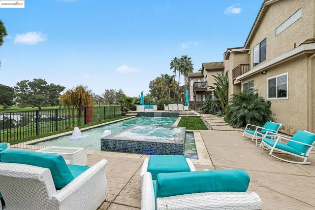 a view of a patio with couches and table and chairs with wooden fence