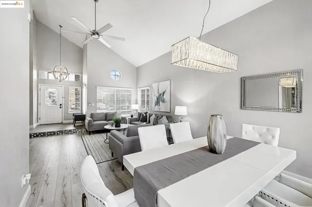 a living room with furniture a chandelier and a dining table