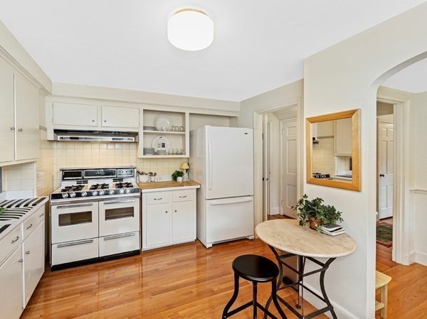 8 Monadnock Road Arlington, MA 02476 - Photo 13 of 36 a kitchen with a stove a refrigerator and a dining table