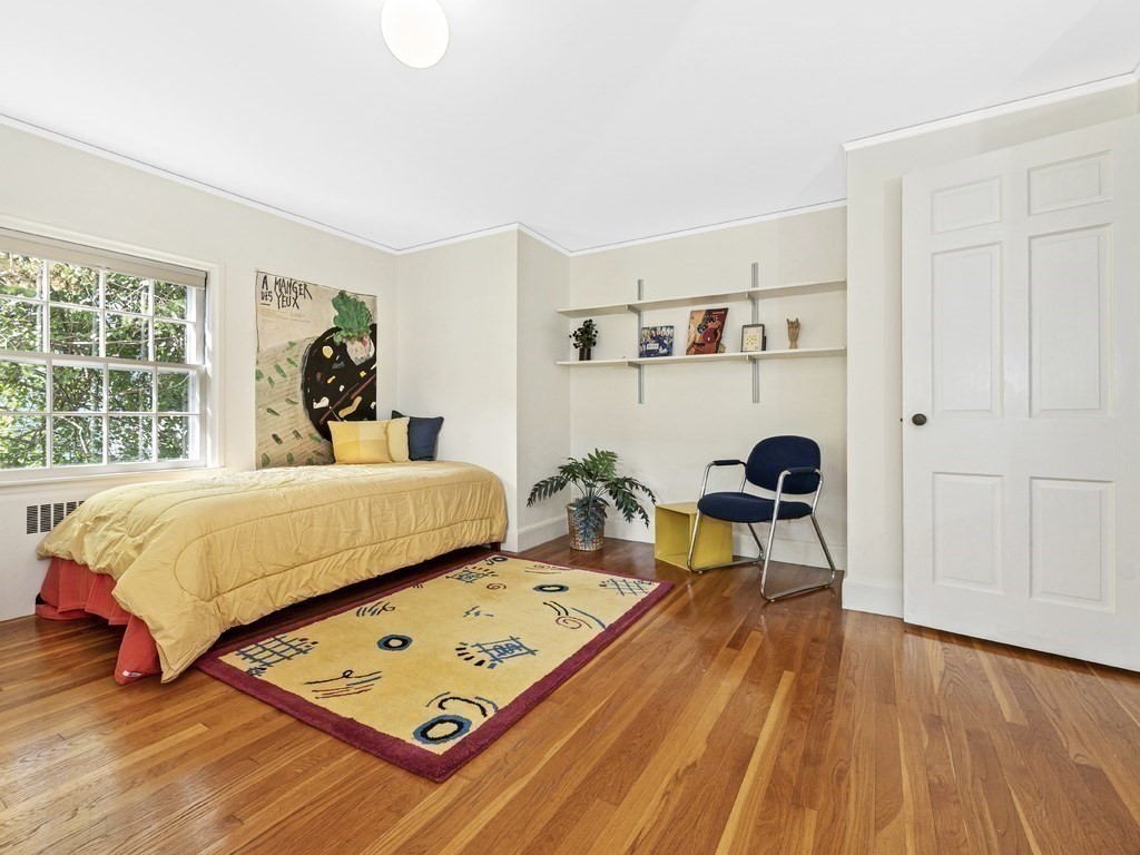 8 Monadnock Road Arlington, MA 02476 - Photo 22 of 36 a bed sitting in a bedroom next to a window with a book shelf