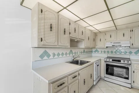a kitchen with white cabinets and white appliances