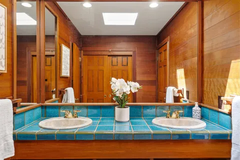 a view of a patio with table and chairs potted plants with wooden floor and large tree