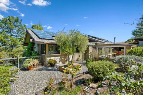 an aerial view of residential house with outdoor space and trees all around