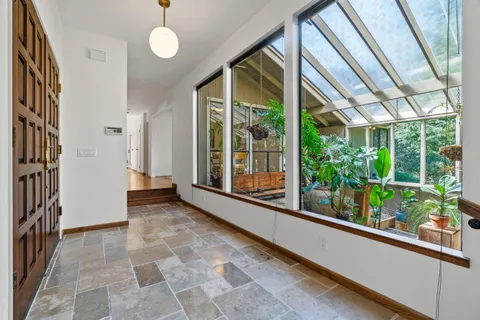 a view of a room with a large windows and plants
