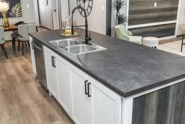 a kitchen with stainless steel appliances granite countertop a sink and a refrigerator