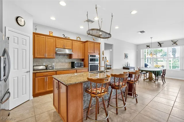 a kitchen with stainless steel appliances granite countertop a stove a microwave and a refrigerator
